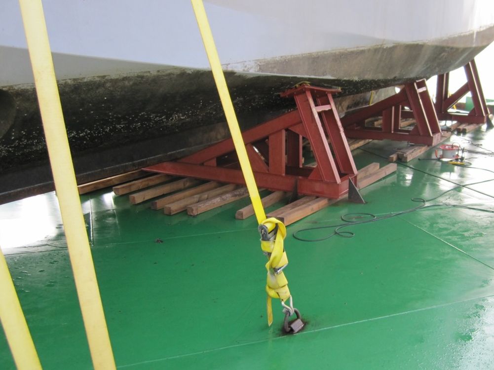 Coque calée sur son ber et saisie au pont d'un cargo, sur lit de bois
