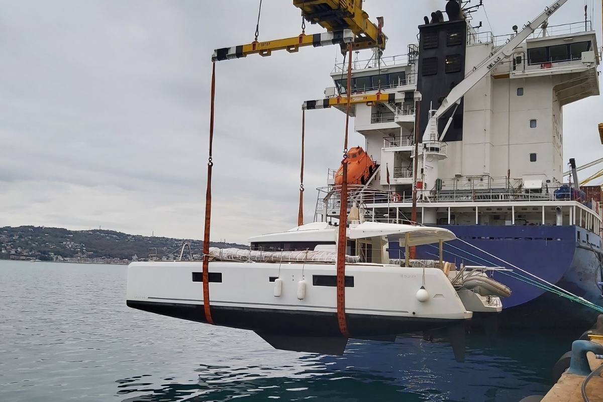 Catamaran soulevé à flot le long d'un cargo