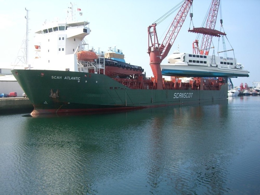 Ferry rapide hissé à bord d'un cargo par ses grues