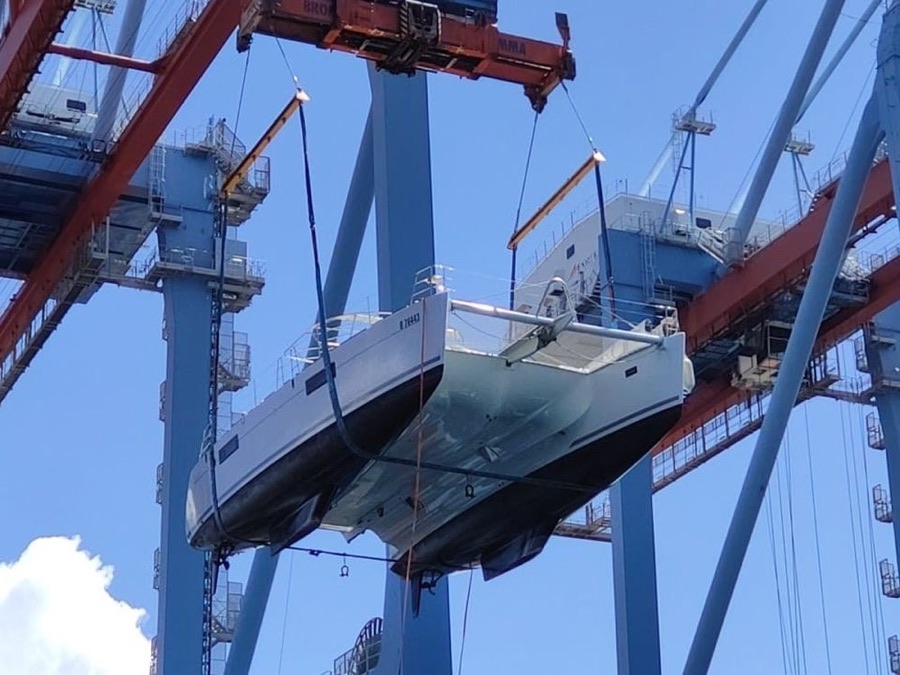 Voilier catamaran de 56 pieds levé par les portiques du terminal, Pointe-des-Galets vers Valence