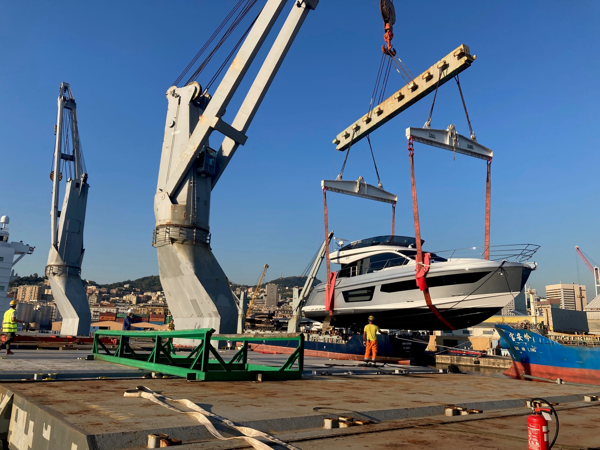 Yacht de luxe levé au palonnier au-dessus d'un cargo