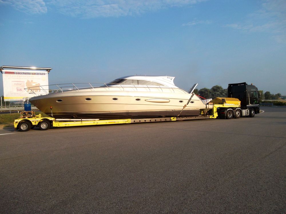 Yacht sanglé sur une remorque surbaissée, prêt pour le pré-acheminement routier
