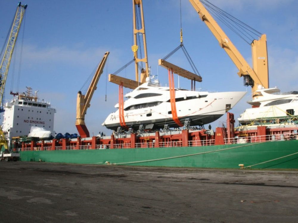 Deux yachts de luxe soulevés par les grues d'un cargo